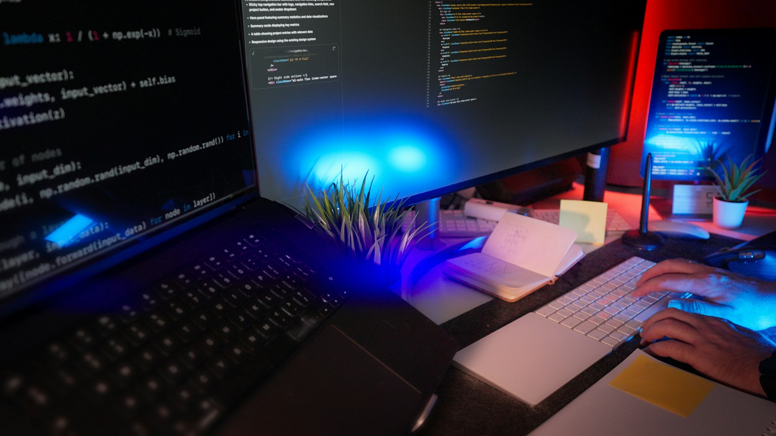 Developer workstation with screens showing code and blue lighting